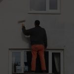 Contractor painting a home exterior