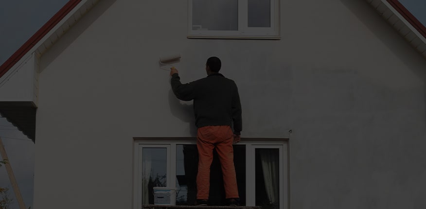 Contractor painting a home exterior